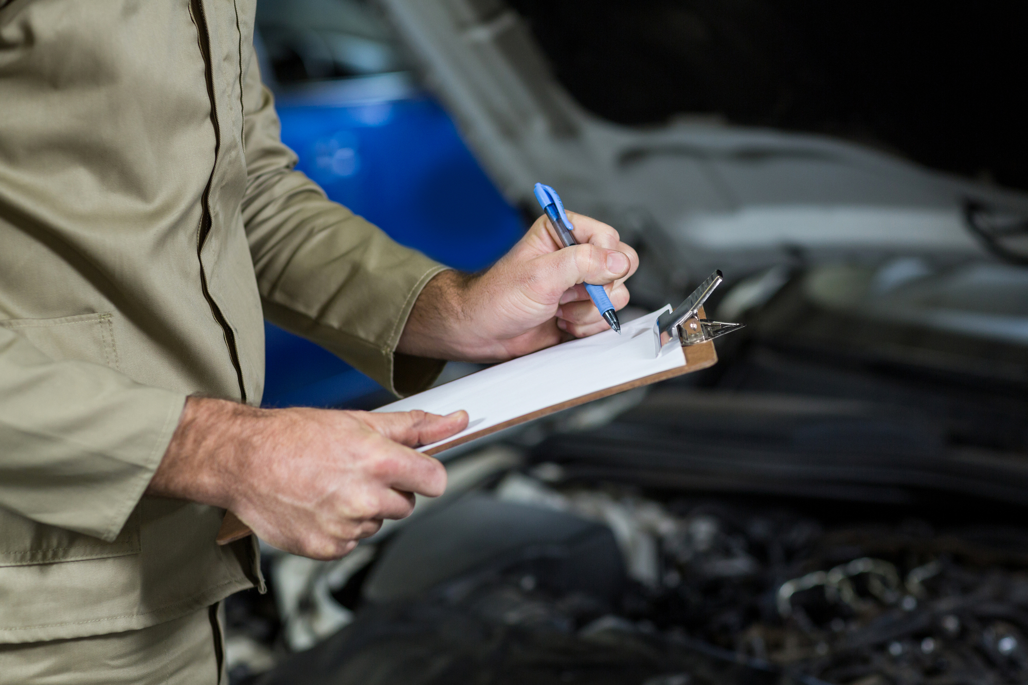 Mid-section of mechanic preparing a check list Hórus Engenharia e Manutenção de Elevadores